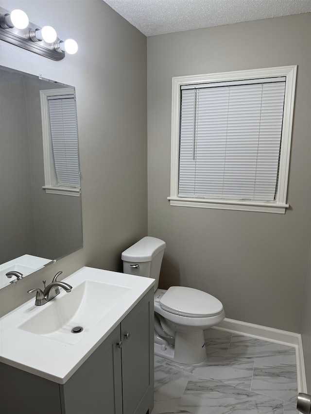 bathroom featuring toilet, vanity, and a textured ceiling