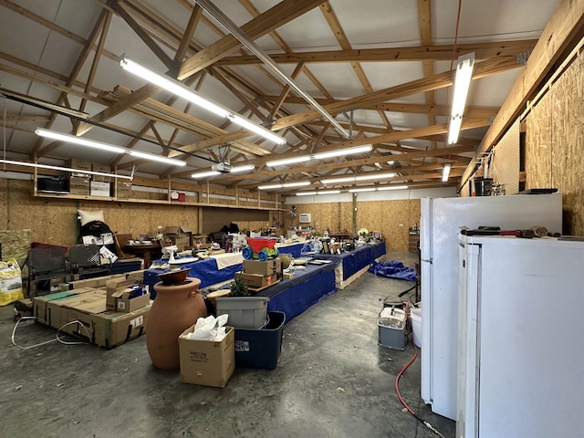 garage featuring a workshop area, a garage door opener, and fridge