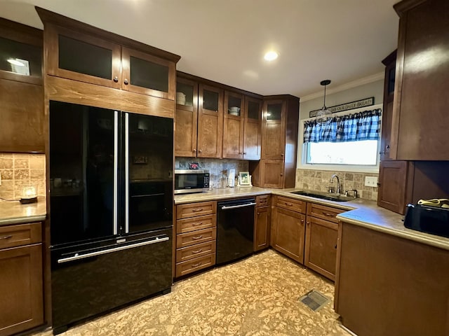 kitchen with sink, backsplash, crown molding, pendant lighting, and black appliances