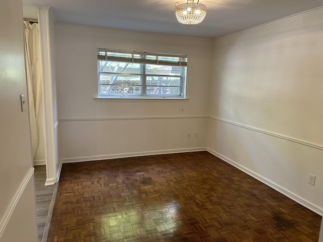 spare room featuring a chandelier and dark parquet floors