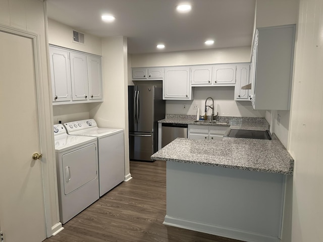 kitchen featuring dark wood-type flooring, white cabinets, sink, washing machine and dryer, and stainless steel appliances