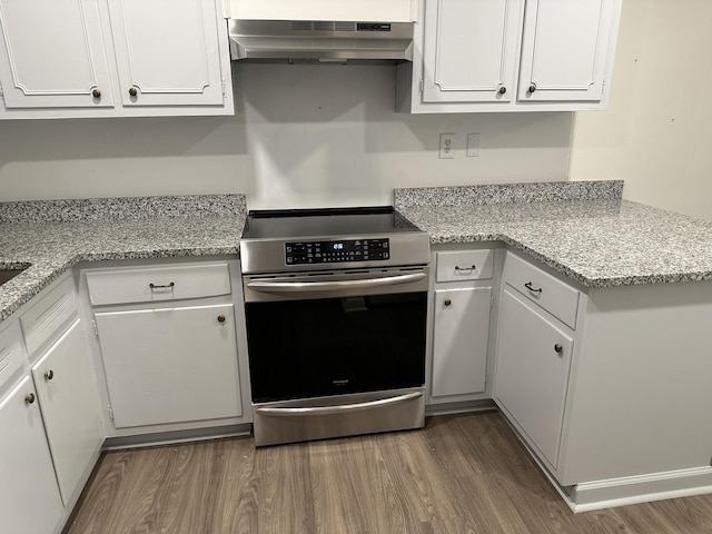 kitchen featuring stainless steel range oven, white cabinets, dark hardwood / wood-style floors, and range hood