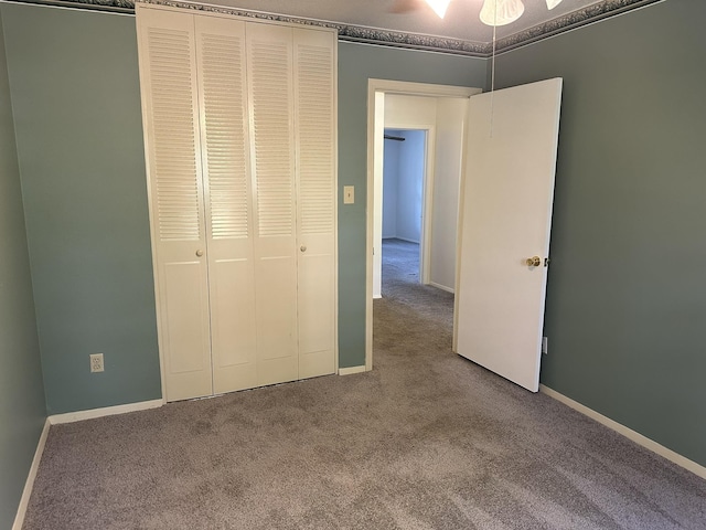 unfurnished bedroom featuring ceiling fan, a closet, and carpet