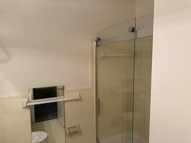 bathroom featuring toilet, tile walls, and walk in shower