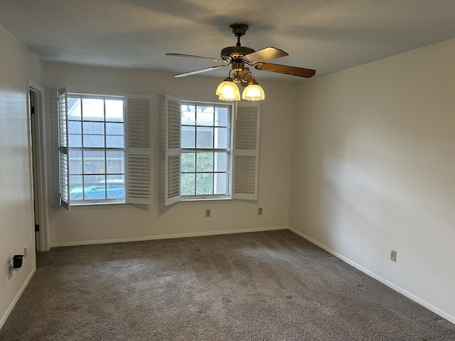 carpeted spare room with a textured ceiling, plenty of natural light, and ceiling fan