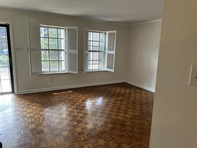 empty room featuring dark parquet flooring, a wealth of natural light, and crown molding