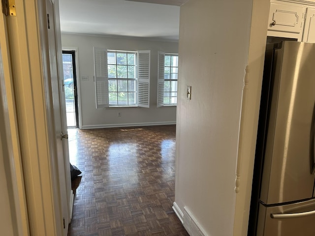 hall with dark parquet floors and ornamental molding