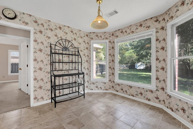 carpeted empty room with a textured ceiling