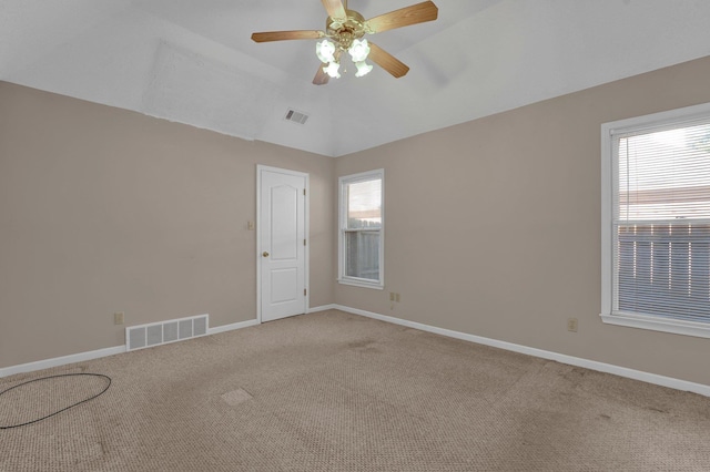 carpeted spare room featuring ceiling fan and lofted ceiling