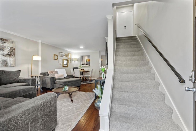 stairs featuring wood-type flooring and ornamental molding