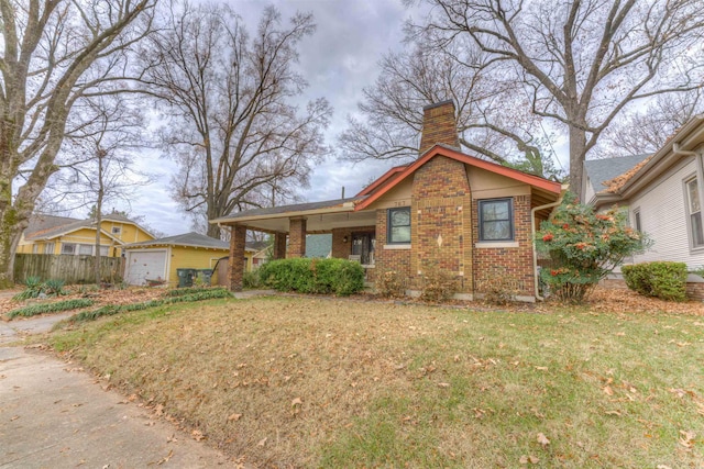 view of front of house with an outbuilding, a garage, and a front lawn