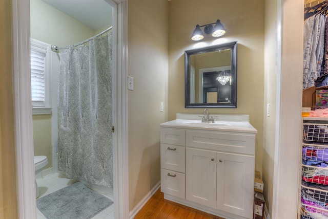 bathroom with curtained shower, vanity, hardwood / wood-style flooring, and toilet