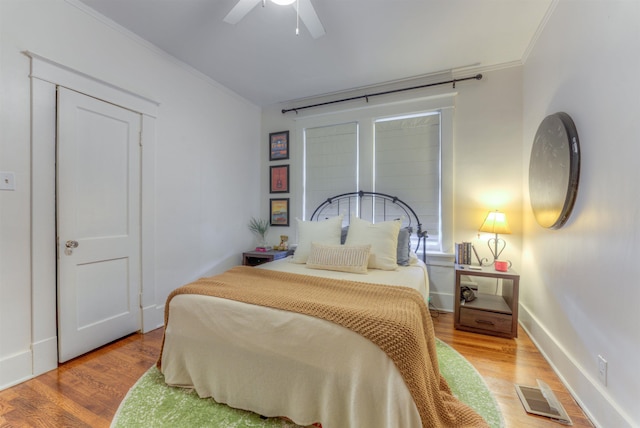 bedroom with ceiling fan, light hardwood / wood-style floors, and ornamental molding