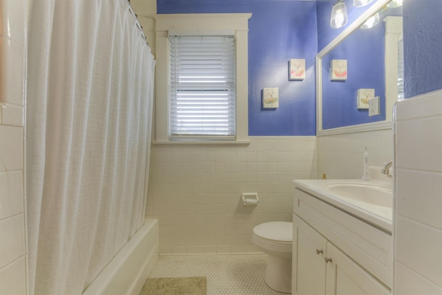 full bathroom featuring shower / bath combo, tile patterned floors, toilet, vanity, and tile walls