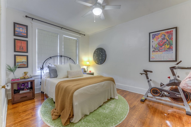 bedroom with ceiling fan, ornamental molding, and hardwood / wood-style flooring