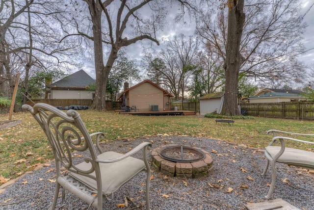 view of yard with a fire pit, a storage unit, and a wooden deck