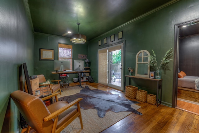 living area with hardwood / wood-style floors and ornamental molding