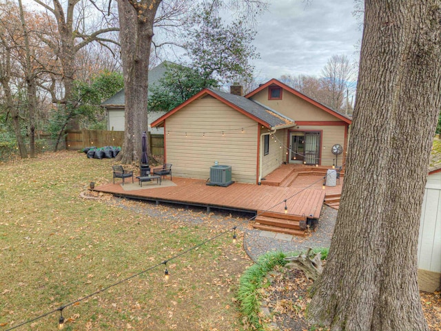 back of house with a deck and a lawn