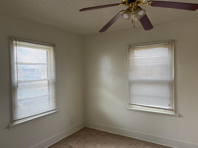 carpeted spare room featuring ceiling fan and a textured ceiling