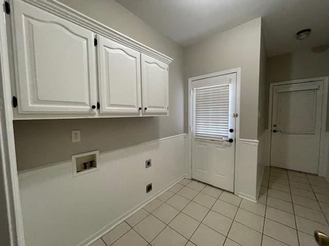 laundry area with hookup for an electric dryer, light tile patterned flooring, cabinets, and hookup for a washing machine