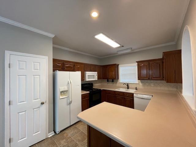 kitchen with white appliances, crown molding, sink, tasteful backsplash, and kitchen peninsula