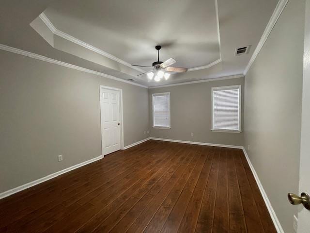 unfurnished room featuring dark hardwood / wood-style floors, ceiling fan, a raised ceiling, and ornamental molding