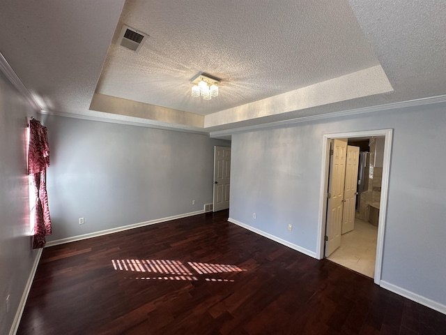 unfurnished room featuring hardwood / wood-style flooring, a raised ceiling, a notable chandelier, and crown molding