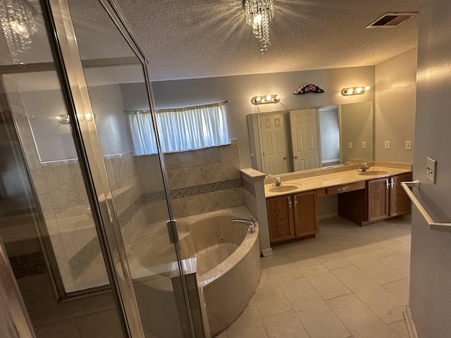 bathroom featuring tile patterned floors, vanity, a textured ceiling, and separate shower and tub