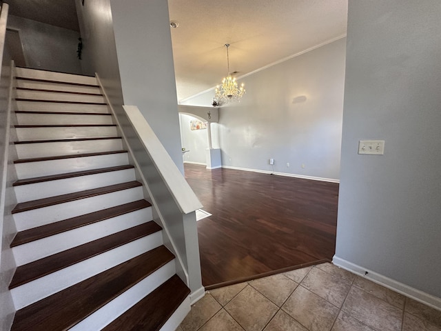 stairway featuring tile patterned floors, a notable chandelier, and ornamental molding