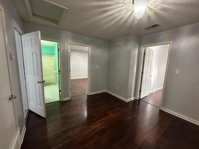 spare room featuring a textured ceiling and dark wood-type flooring