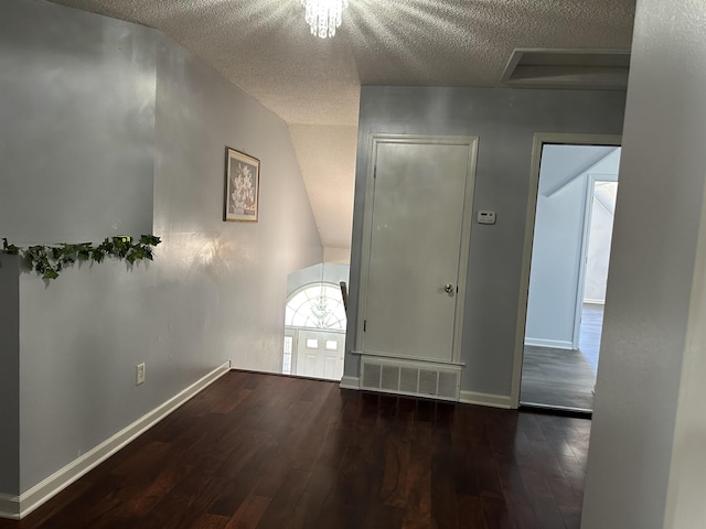 empty room with a textured ceiling and dark wood-type flooring