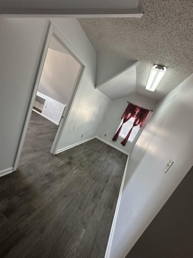 bonus room with vaulted ceiling, dark hardwood / wood-style flooring, and a textured ceiling