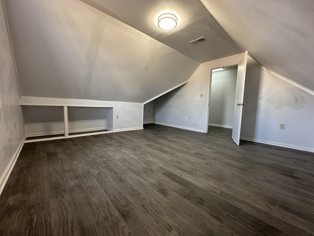 additional living space with built in features, dark hardwood / wood-style flooring, and lofted ceiling