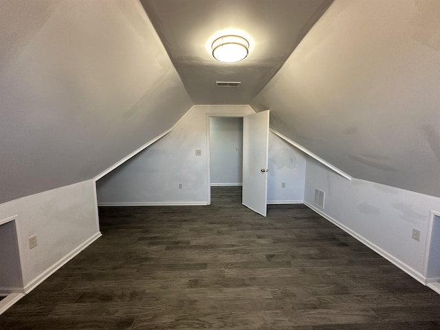 bonus room featuring dark wood-type flooring and vaulted ceiling