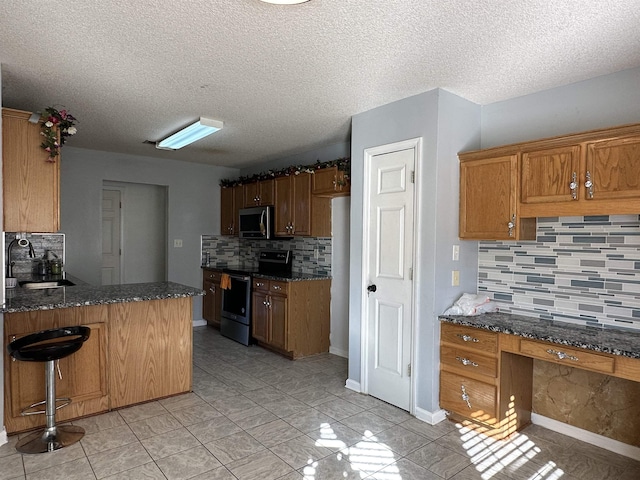 kitchen with sink, backsplash, kitchen peninsula, a textured ceiling, and appliances with stainless steel finishes