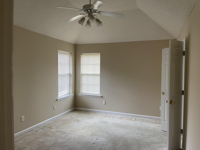 carpeted spare room with a textured ceiling, ceiling fan, and lofted ceiling