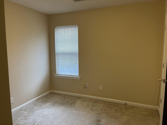 spare room with light colored carpet and a wealth of natural light