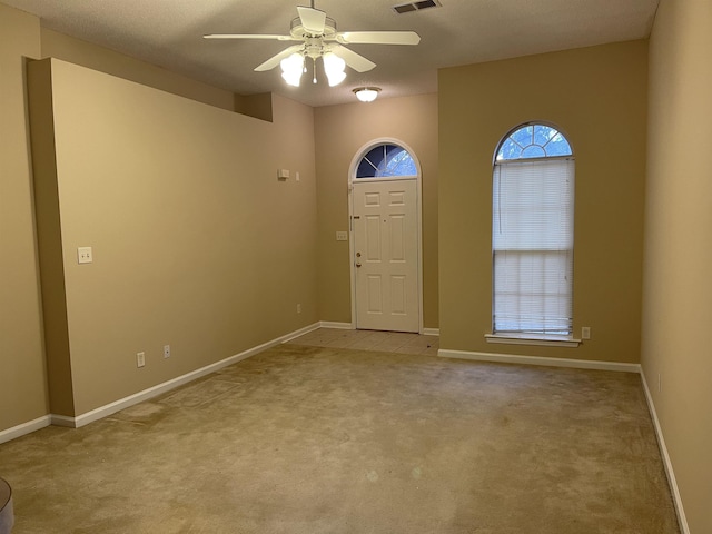 carpeted entrance foyer featuring ceiling fan