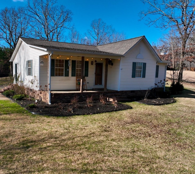 ranch-style house featuring covered porch and a front lawn