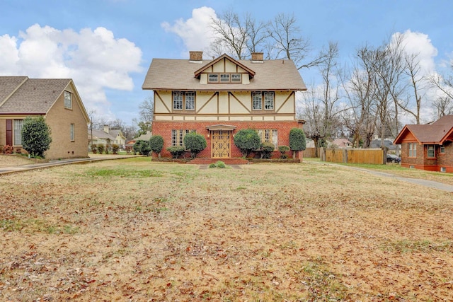 tudor home with a front lawn