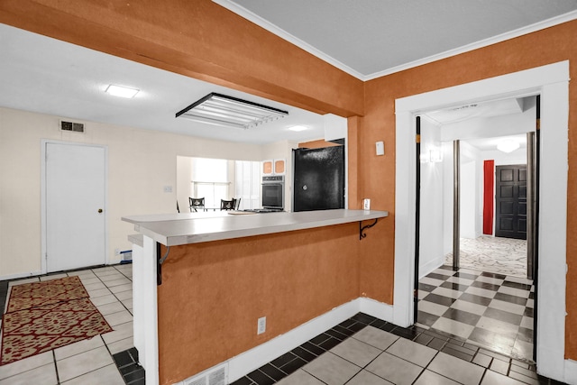 kitchen with kitchen peninsula, black refrigerator, light tile patterned floors, and ornamental molding