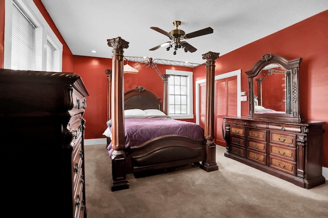 bedroom featuring carpet floors, decorative columns, and ceiling fan