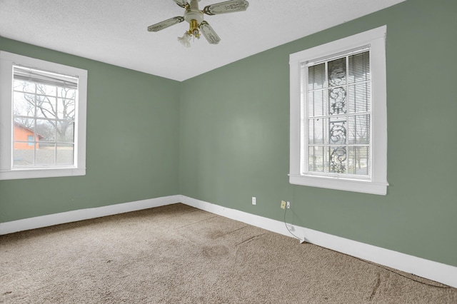 carpeted spare room featuring a textured ceiling and ceiling fan