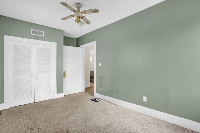 unfurnished bedroom with carpet floors, a closet, and ceiling fan