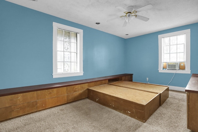 bedroom with ceiling fan, cooling unit, light colored carpet, and a textured ceiling