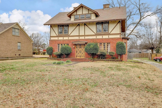 english style home featuring a front yard