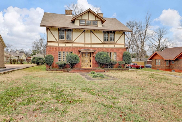 tudor home with a front lawn