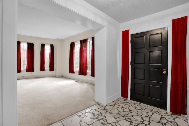 carpeted entrance foyer with a textured ceiling