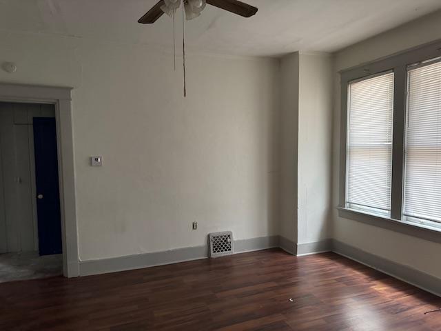 unfurnished room featuring dark hardwood / wood-style flooring, plenty of natural light, and ceiling fan