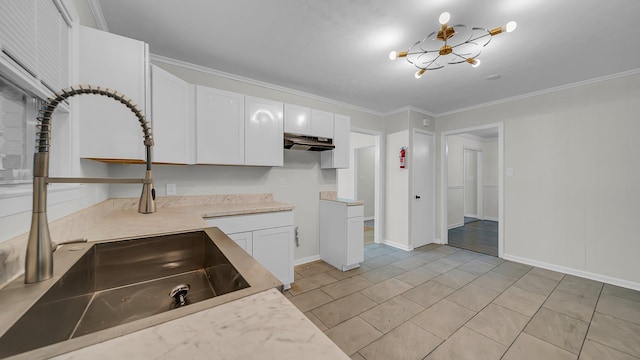 kitchen featuring crown molding, sink, light tile patterned floors, white cabinetry, and a chandelier